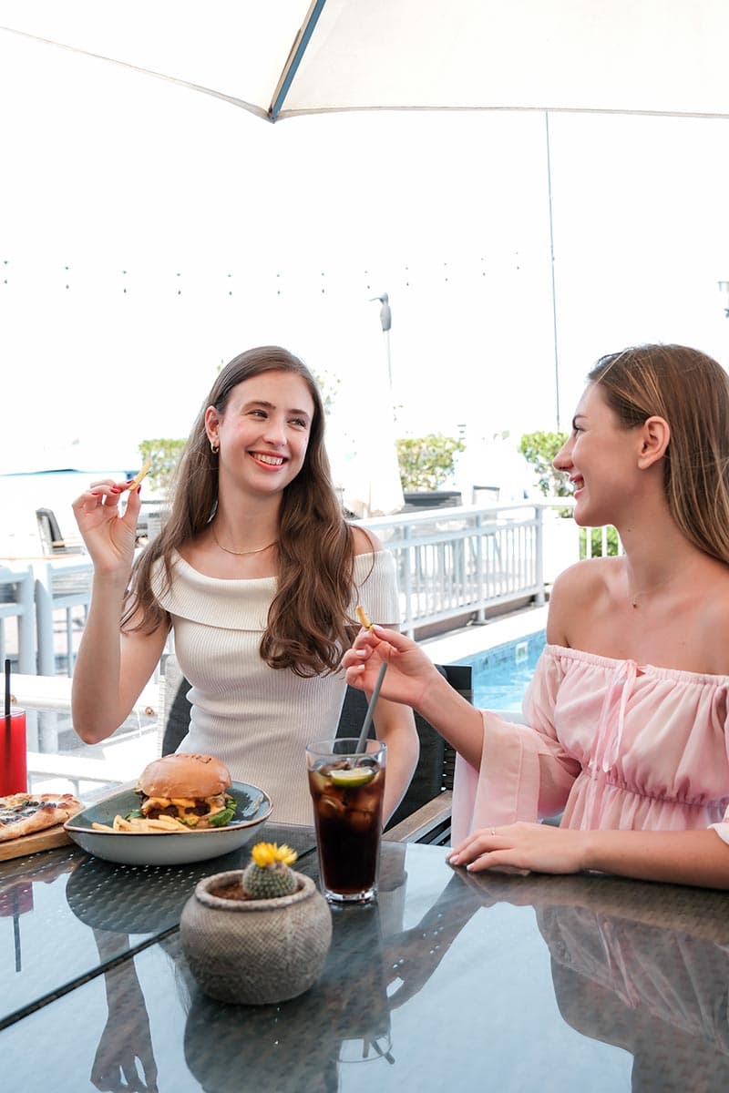 Casual dining and conversation by the pool at Riva